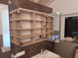 Spiegelschrank mit doppelseitigen Spiegeltüren und integrierter Steckdose