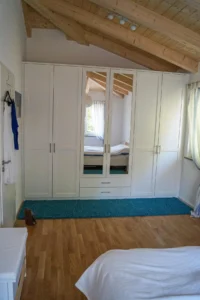 Schlafzimmerschrank mit Spiegel und Füllungen in Weißlack