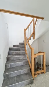 Holzgeländer an gefliester Treppe mit Edelstahlstäben