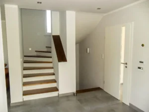 Treppe zwischen zwei Wänden mit weißen Setzstufen und passender Mauerabdeckung