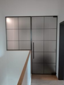 Glastür satiniert mit schwarzen Details und halbhohem festen Seitenteil